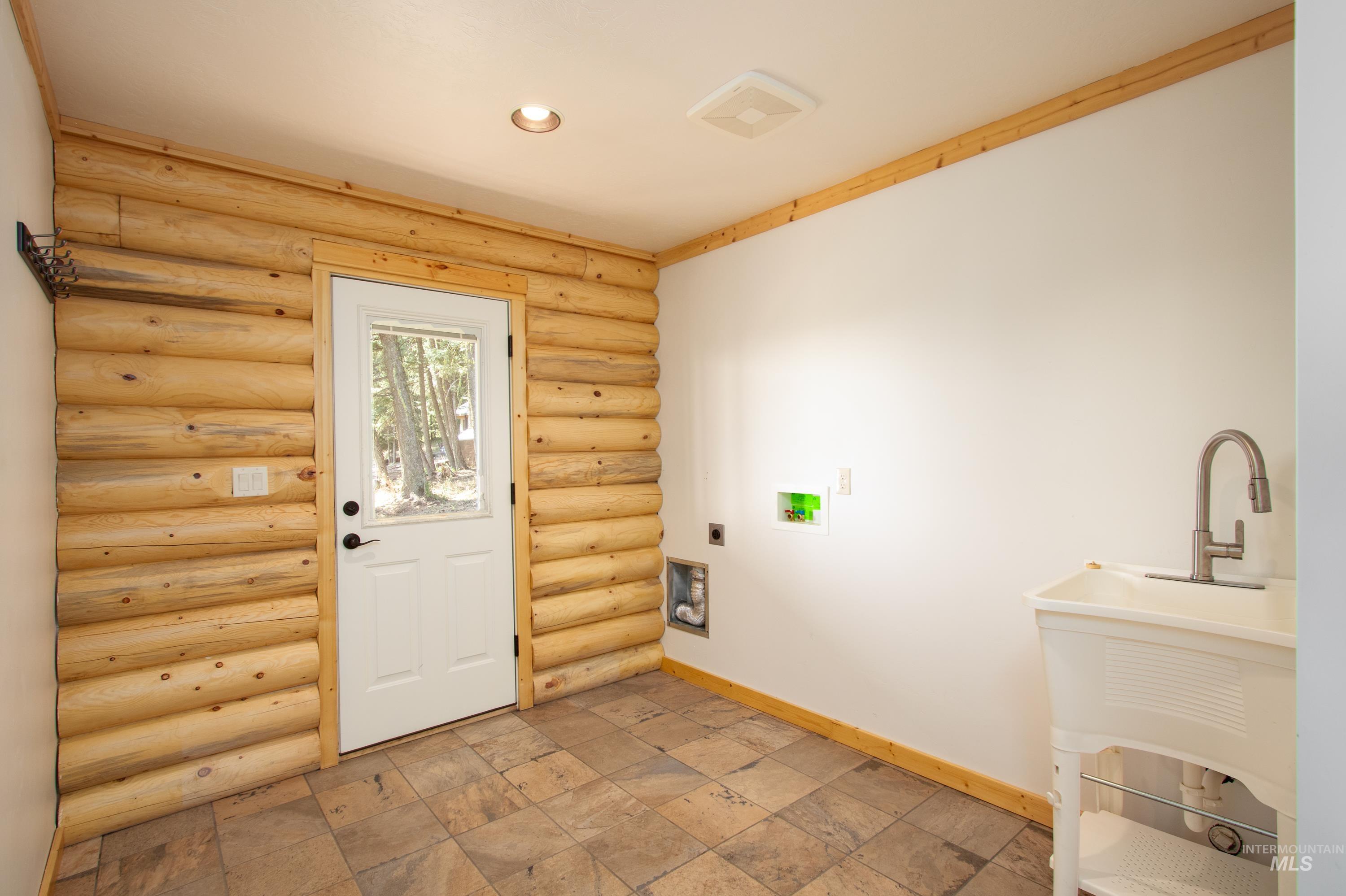 1539 West Mountain Road Cascade, ID 83611 - Photo 18 of 33 Laundry room featuring washer hookup, light stone finish flooring, rustic walls, hookup for an electric dryer, and recessed lighting