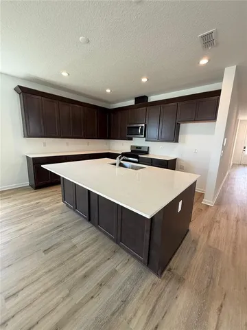 a kitchen with stainless steel appliances a stove top oven a refrigerator a sink and a oven