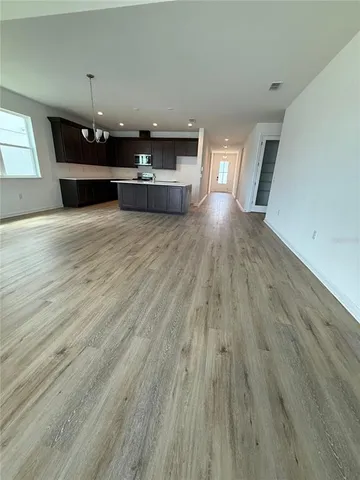 a view of a room with wooden floor and chandelier