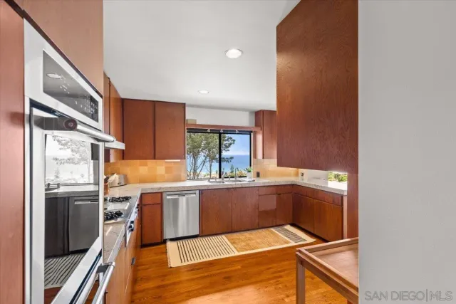 a kitchen with stainless steel appliances granite countertop a sink and cabinets