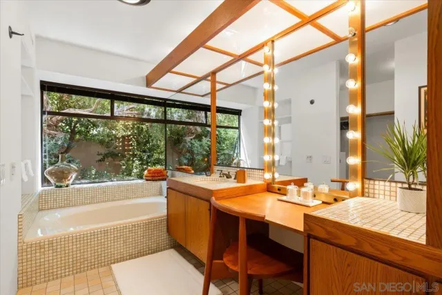 a bathroom with a sink a bathtub and next to a window
