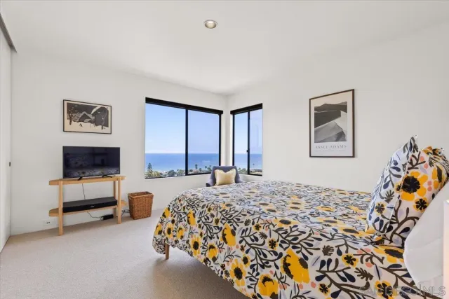 a bedroom with a bed and large windows