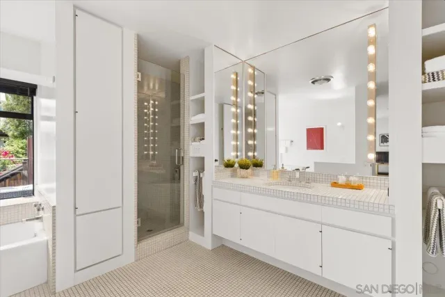 a bathroom with a double vanity sink mirror and shower