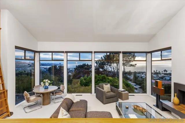 a living room with furniture and floor to ceiling windows