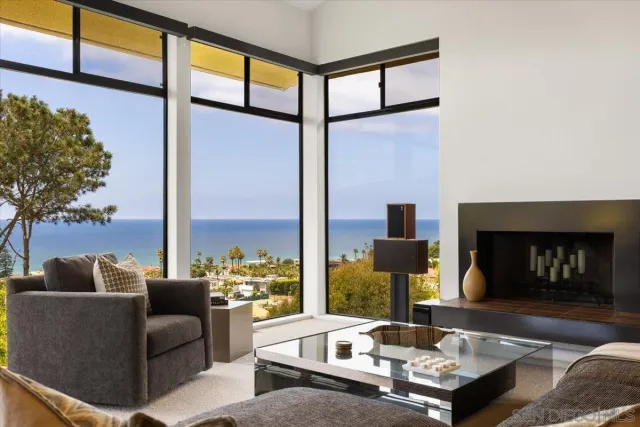 a living room with fireplace furniture and a floor to ceiling window