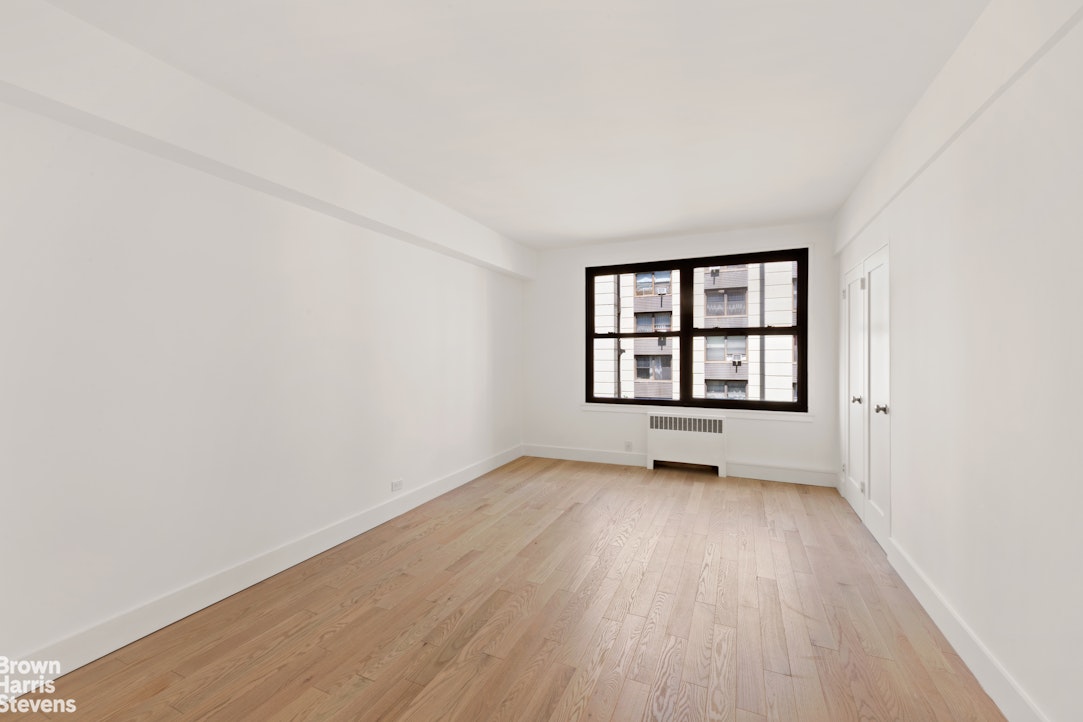 98-41 64th Road, Unit 3G Queens, NY 11374 - Photo 12 of 14 an empty room with wooden floor and windows