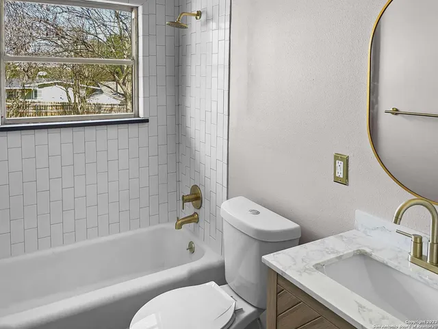 a white toilet sitting next to a bath tub