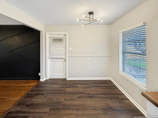 a kitchen with a sink a stove top oven a refrigerator and white cabinets