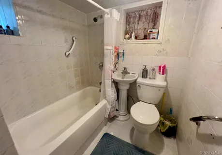 a white toilet sitting next to a bath tub