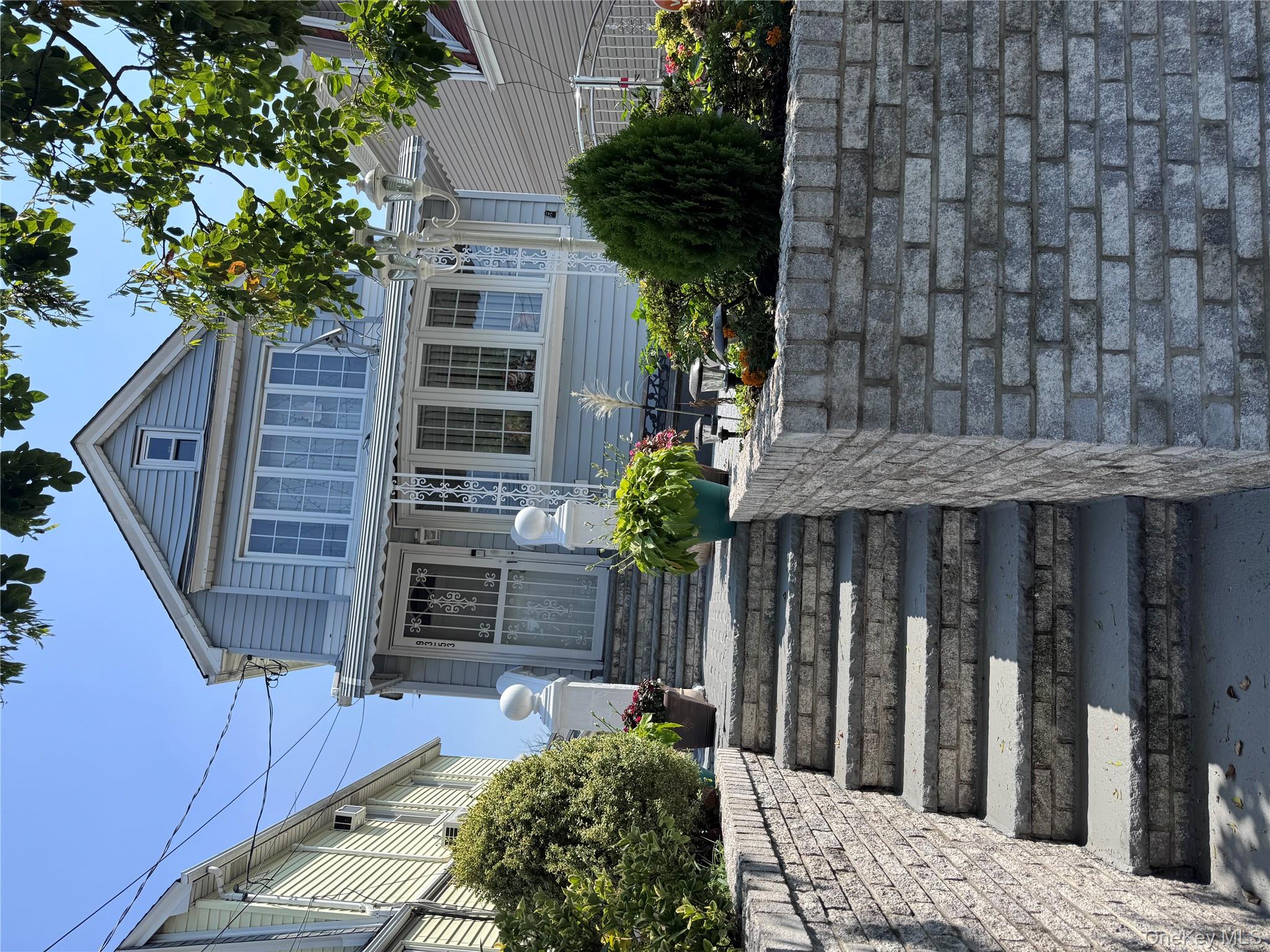 93-53 207th Street Queens, NY 11428 - Photo 2 of 36 a front view of a house with potted plants