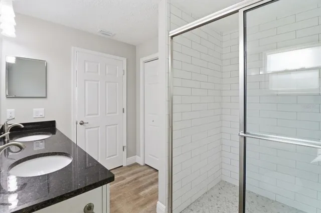 a bathroom with a granite countertop sink and a mirror
