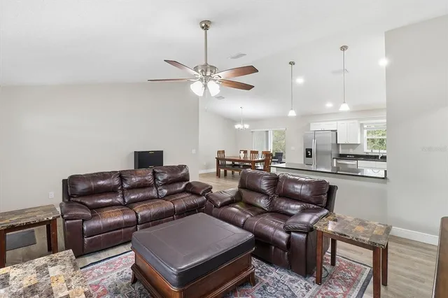 a living room with furniture a ceiling fan and a rug