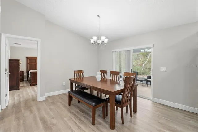 a dining room with furniture a chandelier and wooden floor