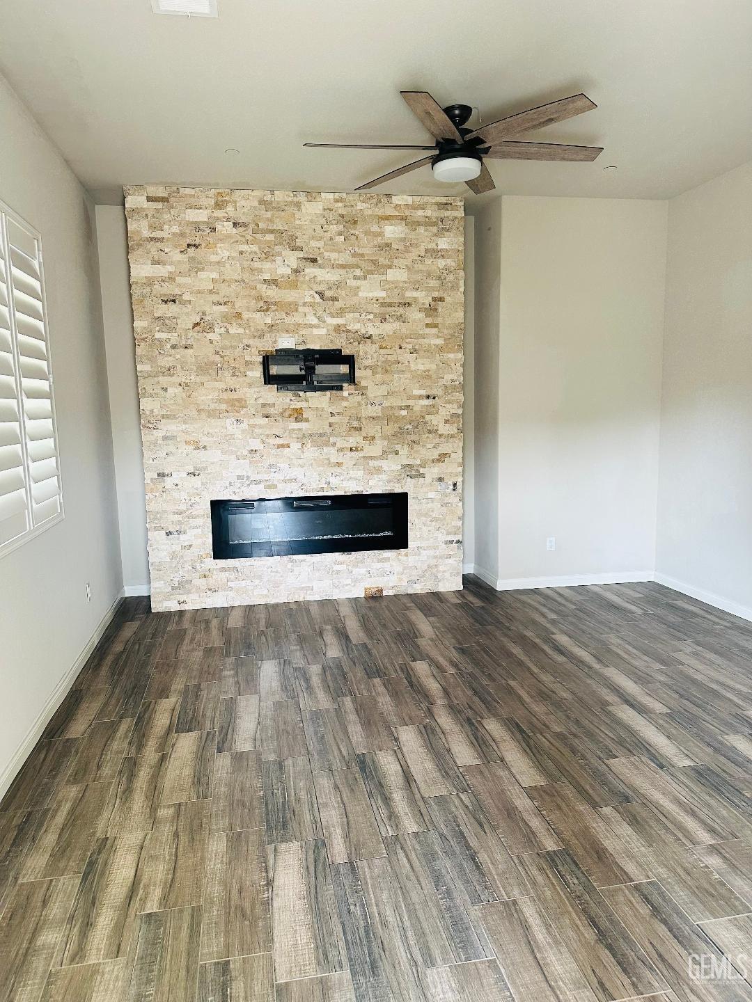 Undisclosed Address Bakersfield, CA 93314 - Photo 11 of 32 a view of empty room with a fireplace and wooden floor