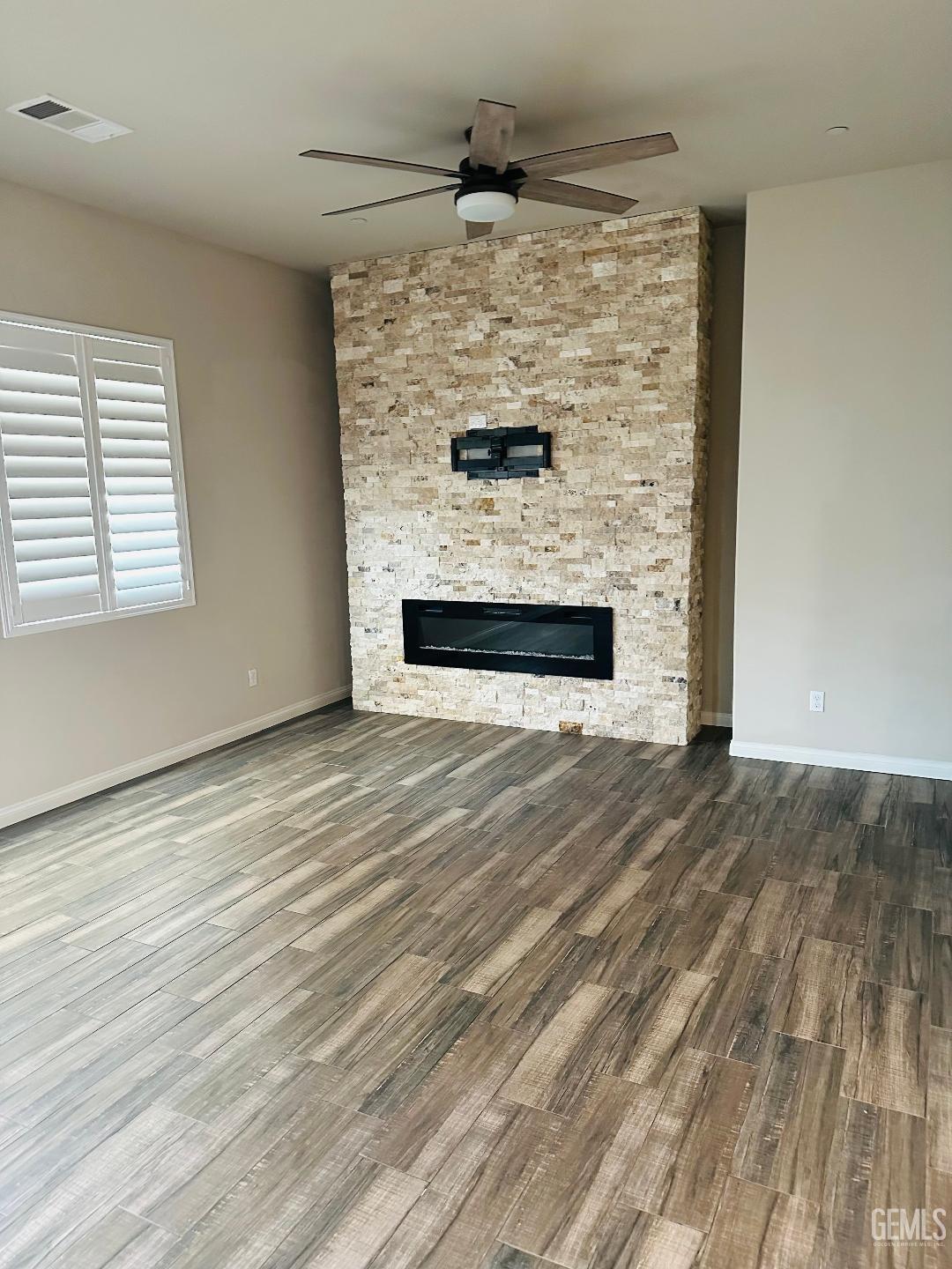 Undisclosed Address Bakersfield, CA 93314 - Photo 12 of 32 an empty room with wooden floor fireplace and window