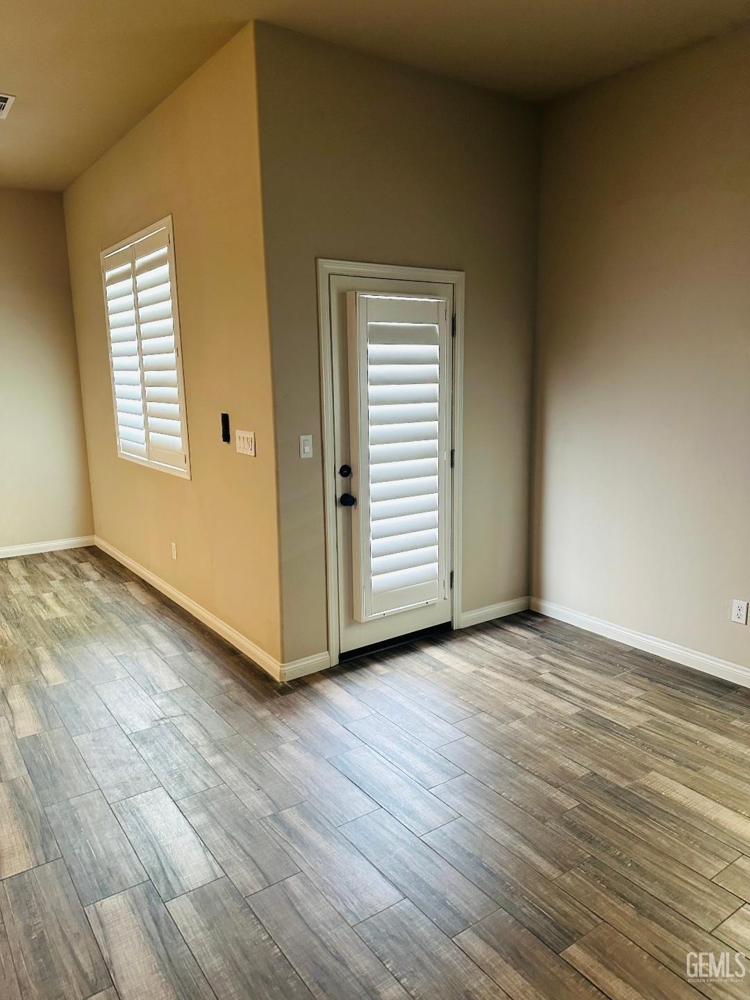 Undisclosed Address Bakersfield, CA 93314 - Photo 16 of 32 an empty room with wooden floor and windows
