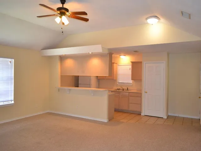 a view of a kitchen with a sink and a refrigerator