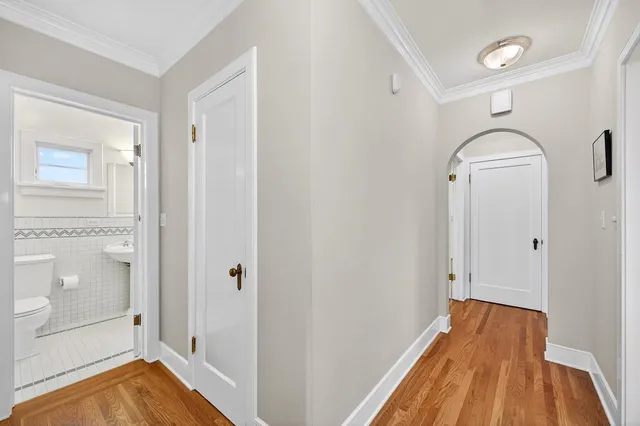 an empty room with wooden floor fireplace and windows