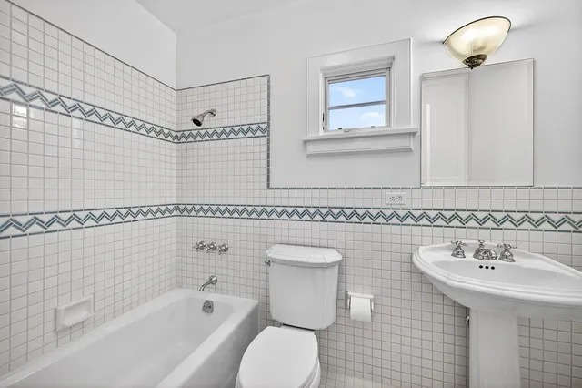 a view of an empty room with wooden floor fireplace and a window