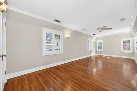 a view of empty room with wooden floor and windows