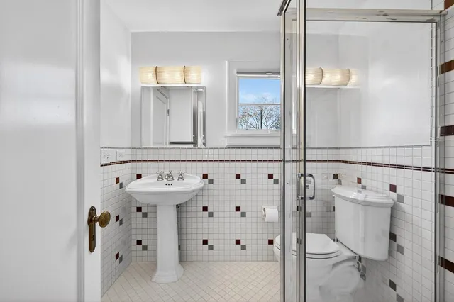 a kitchen with a sink dishwasher and white cabinets with wooden floor