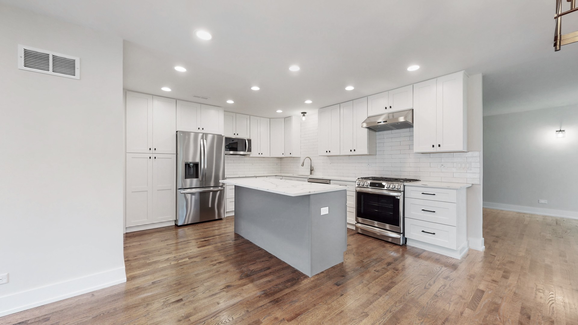 1617 Birch Road Northbrook, IL 60062 - Photo 11 of 32 a large kitchen with stainless steel appliances a stove a sink dishwasher a refrigerator and white cabinets with wooden floor
