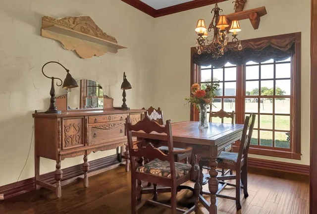 a dining room with furniture a chandelier and wooden floor