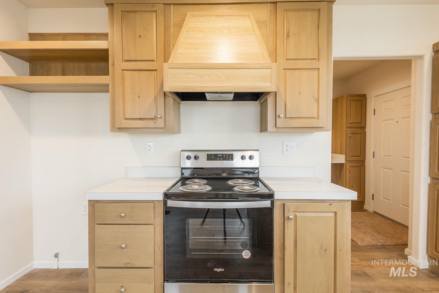 21568 Market Road Parma, ID 83660 - Photo 17 of 22 Kitchen with stainless steel electric range oven, light countertops, light wood-type flooring, and light wood finish cabinetry