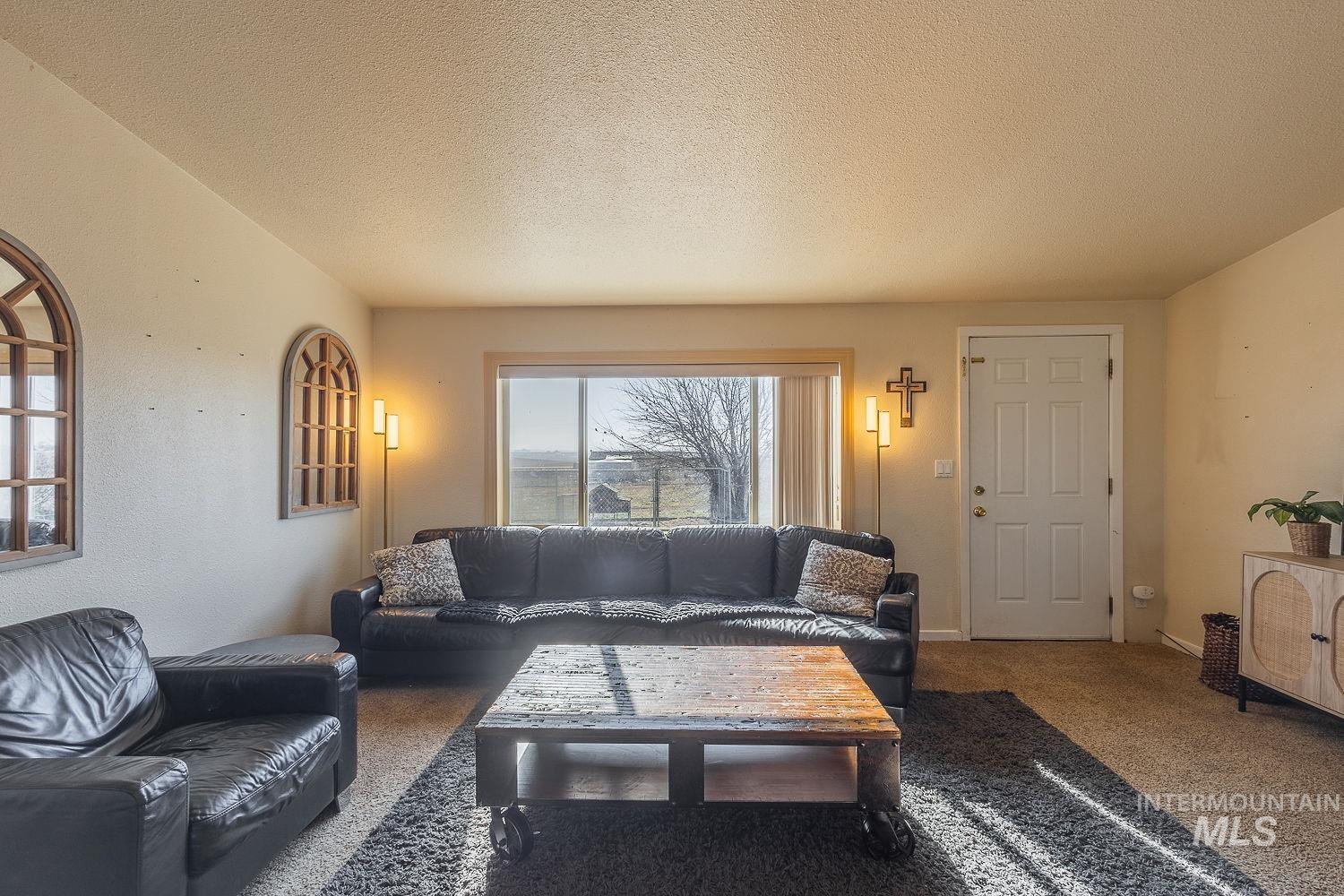 21568 Market Road Parma, ID 83660 - Photo 5 of 22 Carpeted living room with a textured ceiling and baseboards