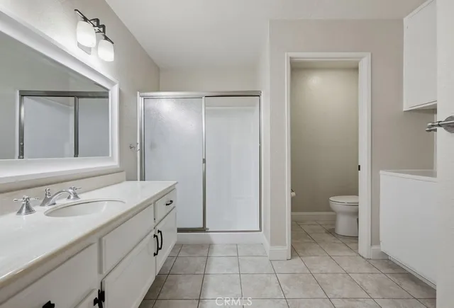 a spacious bathroom with a granite countertop sink toilet and shower