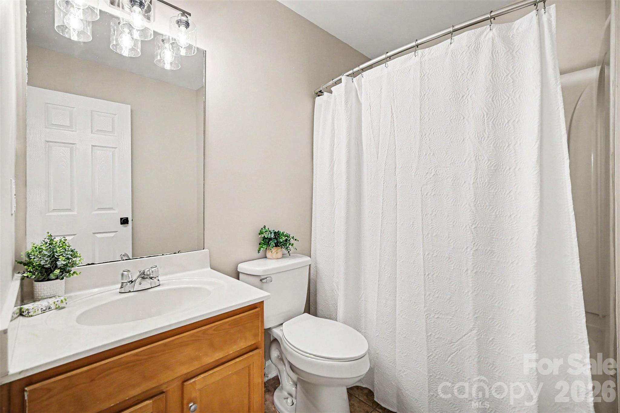 1210 Sheldon Brook Lane Fort Mill, SC 29707 - Photo 21 of 26 a bathroom with a sink a toilet and shower curtain