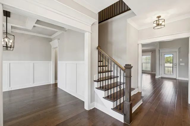 a view of an empty room with wooden floor fireplace and a window