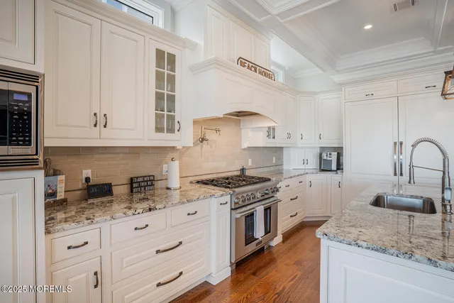 a kitchen with granite countertop white cabinets and white appliances