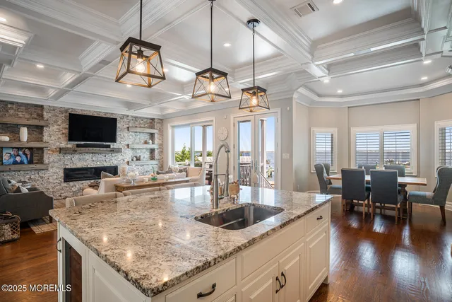 a kitchen with stainless steel appliances granite countertop a sink a stove and a wooden floors