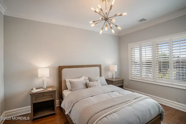 a bedroom with a large bed and a chandelier