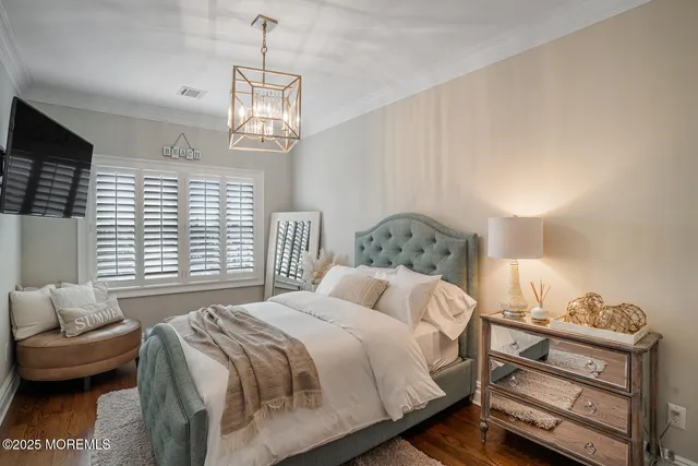 a bedroom with a bed and a chandelier