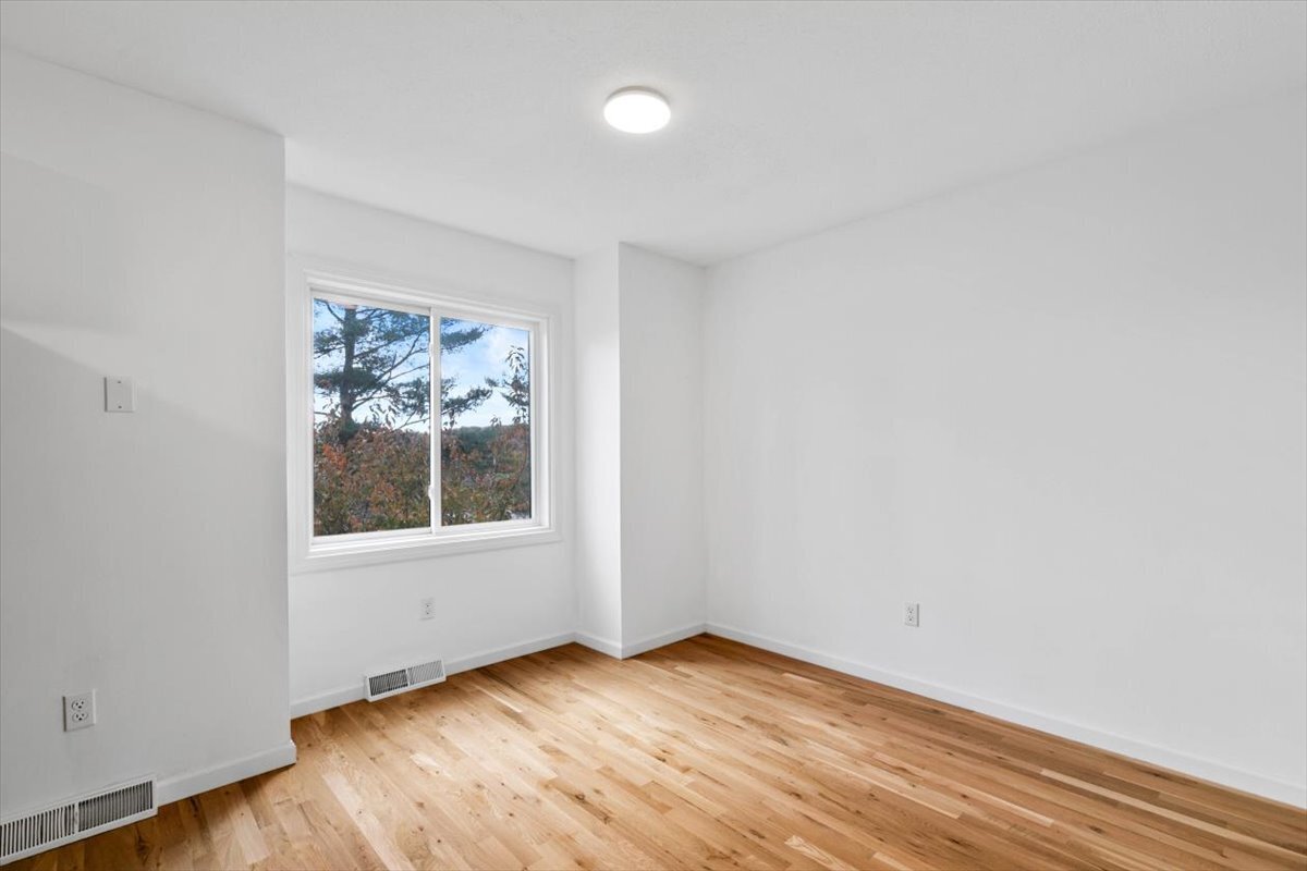 204 New Haven Avenue, Unit 2G Derby, CT 06418 - Photo 21 of 24 an empty room with wooden floor and windows