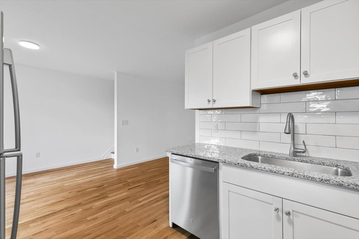 204 New Haven Avenue, Unit 2G Derby, CT 06418 - Photo 7 of 24 a kitchen with granite countertop white cabinets and a sink