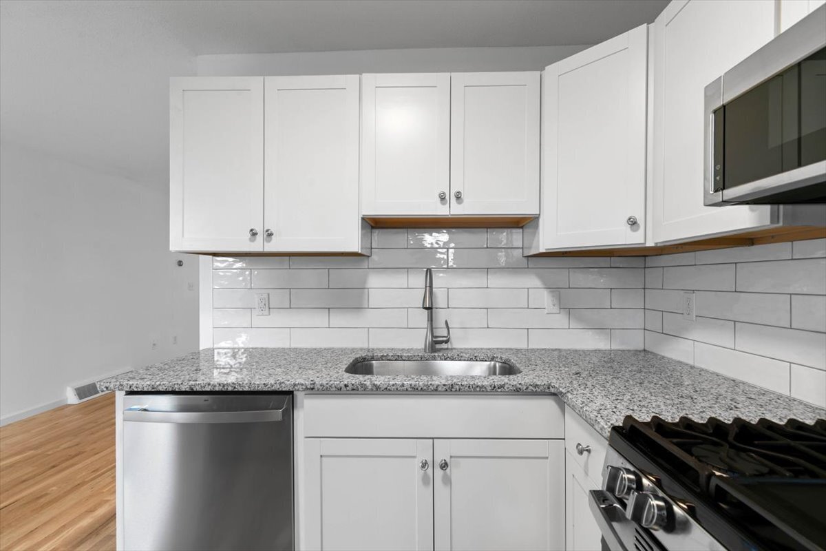 204 New Haven Avenue, Unit 2G Derby, CT 06418 - Photo 10 of 24 a kitchen with granite countertop white cabinets and stainless steel appliances