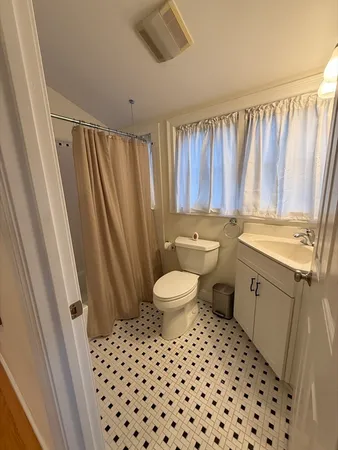 a bathroom with a sink a toilet a mirror and shower