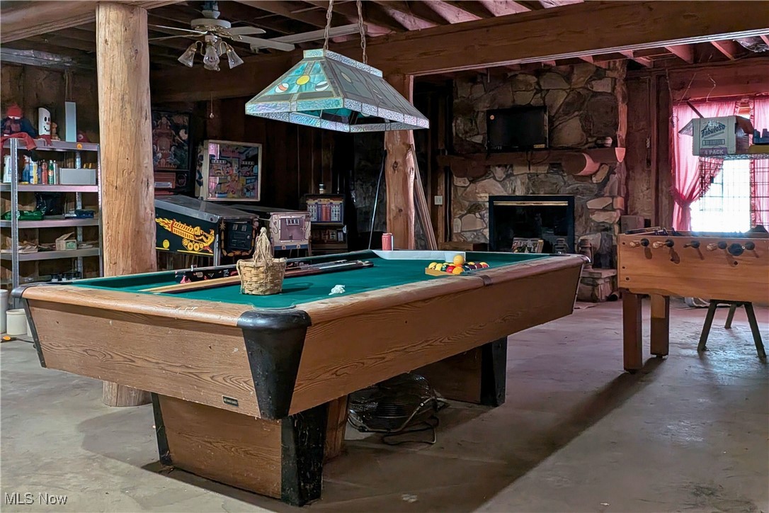 8026 Lee Road Northwest Malvern, OH 44644 - Photo 22 of 44 Recreation room with billiards table, a fireplace, wood walls, and a ceiling fan
