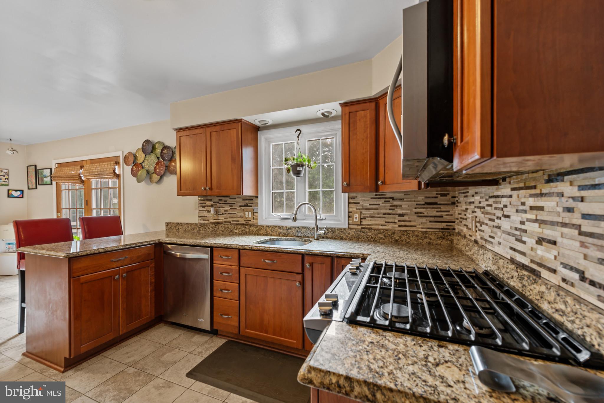 1309 Midmeadow Road Baltimore, MD 21286 - Photo 5 of 37 a kitchen with granite countertop a sink stove and cabinets