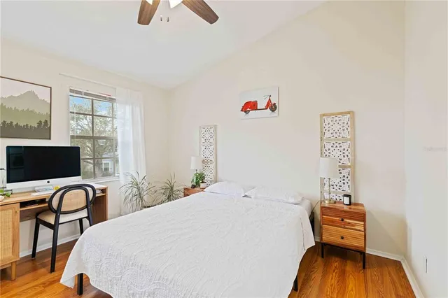 a bedroom with a bed and a flat tv screen on the table