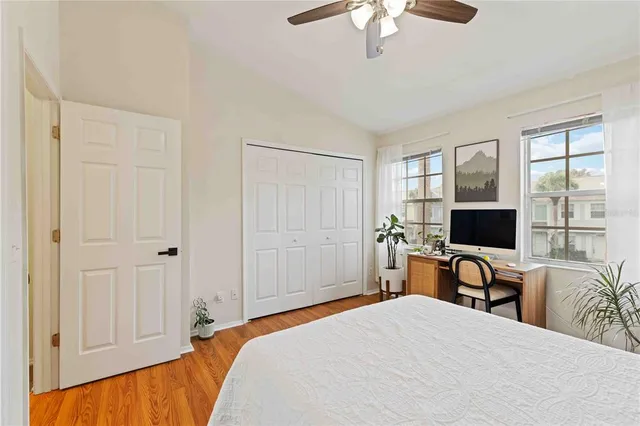 a bedroom with a bed and a flat tv screen next to a window