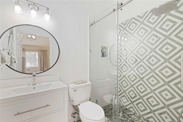 a bathroom with a toilet a sink and mirror