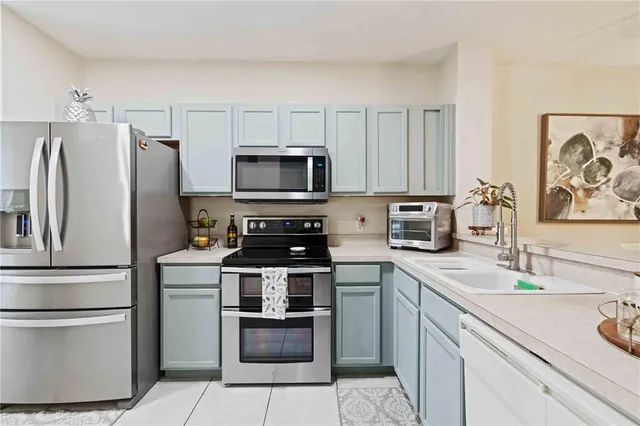 a kitchen with stainless steel appliances a stove microwave and a refrigerator