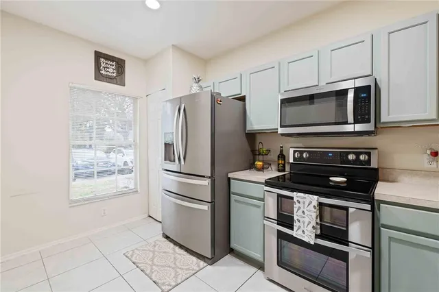 a kitchen with cabinets stainless steel appliances and a window