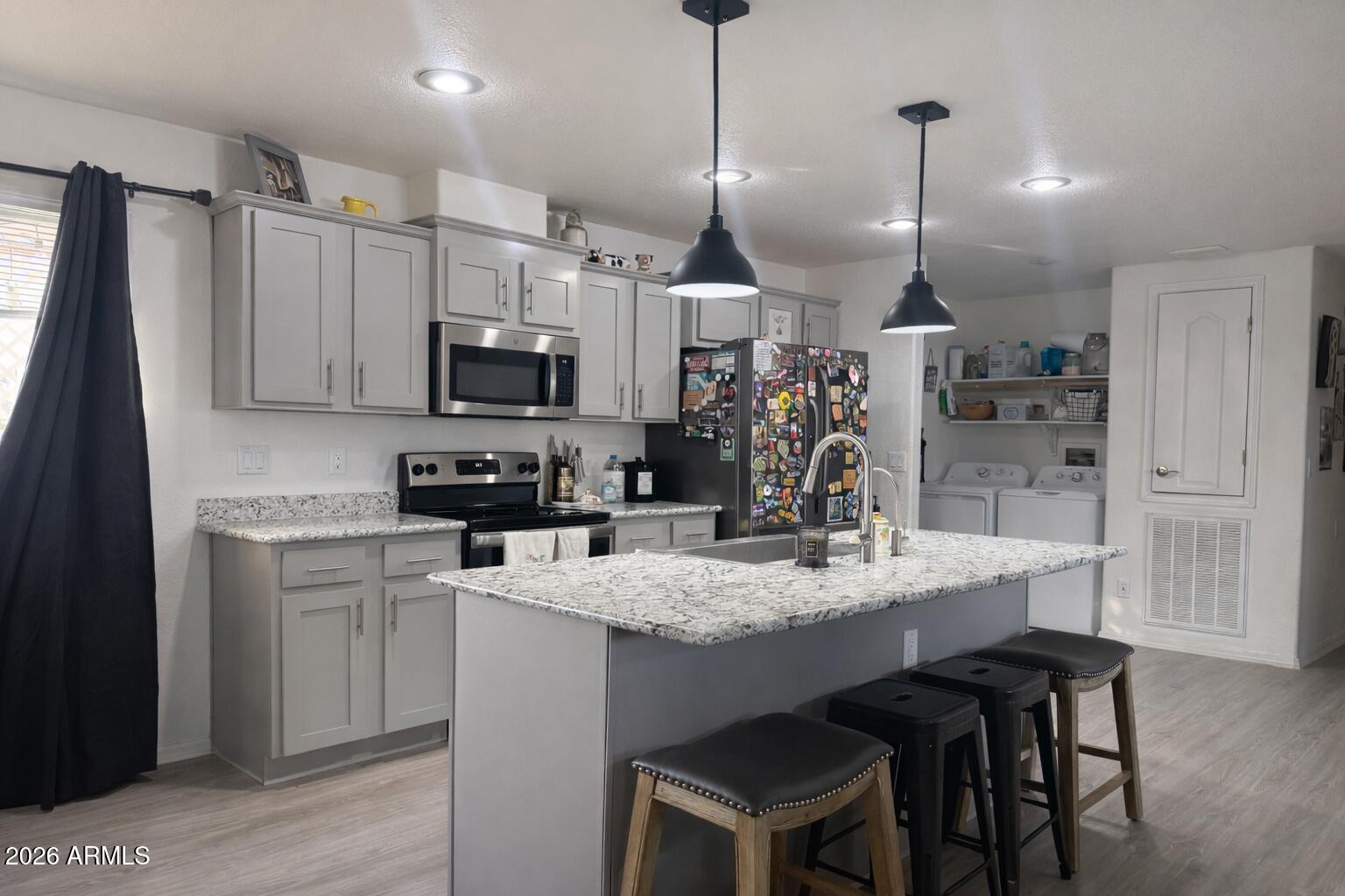 2046 South Mariposa Road Apache Junction, AZ 85119 - Photo 2 of 21 a kitchen with kitchen island granite countertop a sink a counter space appliances and cabinets