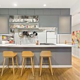 a kitchen with stainless steel appliances granite countertop a table chairs in it and wooden floors