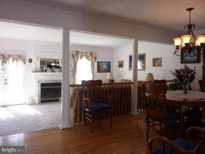 9229 Howland Road Laurel, MD 20723 - Photo 2 of 15 a living room with furniture a dining table and a fireplace
